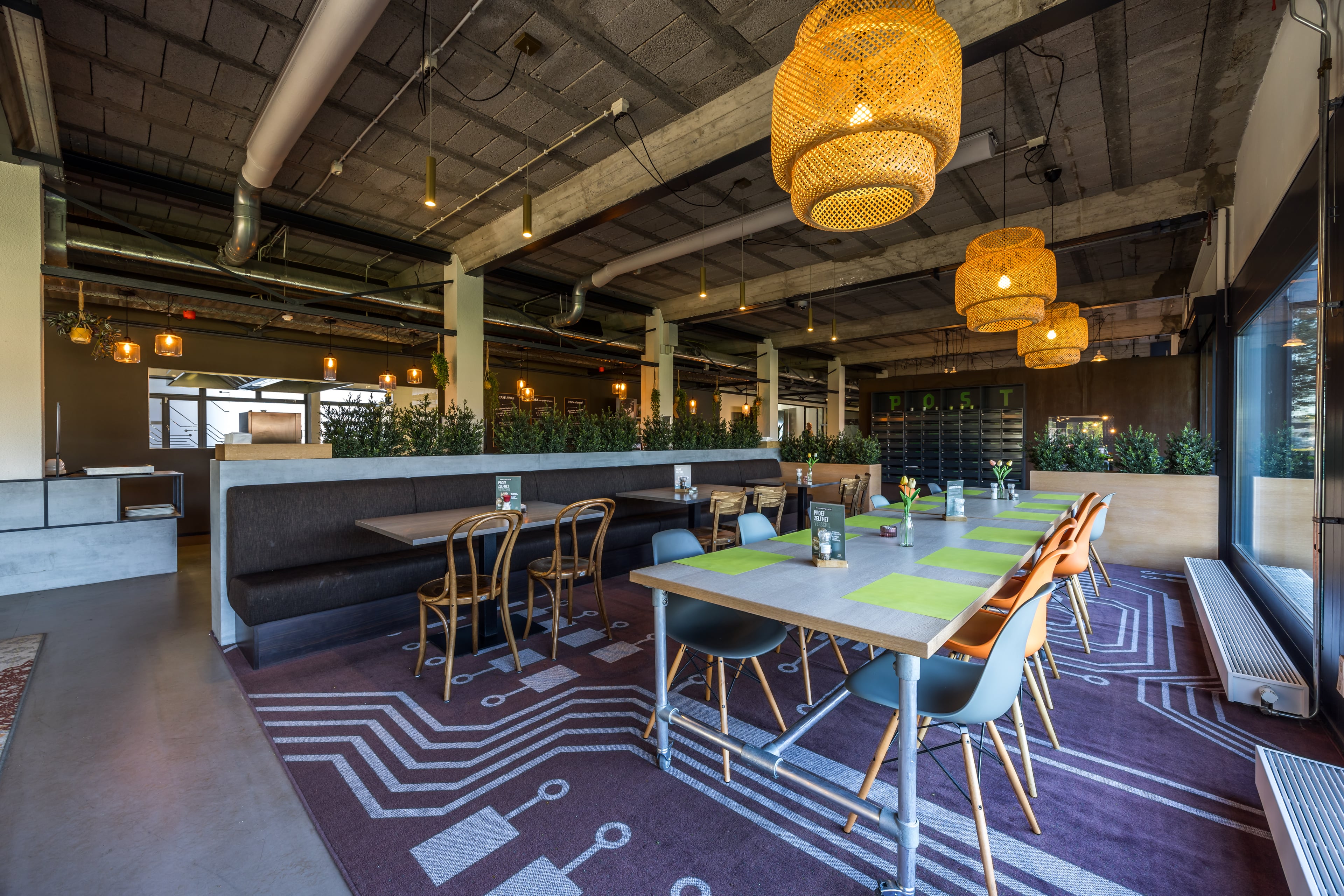 Restaurant met lange tafels, zitbanken en rieten hanglampen